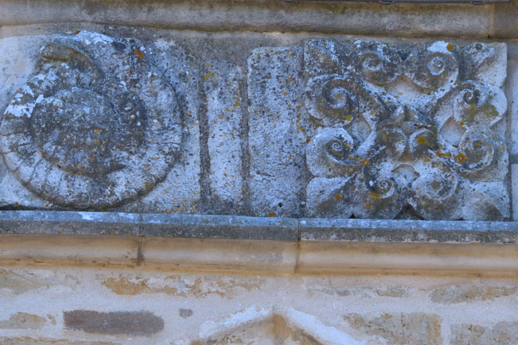 Saint-Père-sous-Vézelay - Médaillons du troisième étage du clocher : l'ammonite fossile et la croix fleurdelisée (XIIIe s.)